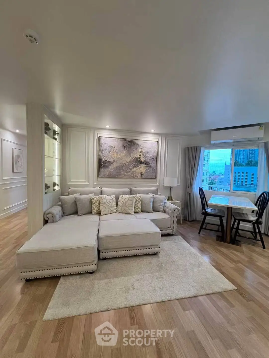 Elegant living room with stylish decor and city view, featuring a cozy sectional sofa and dining area.