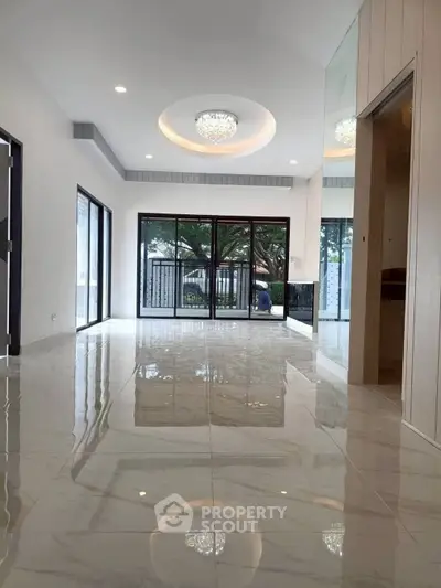 Spacious modern living room with glossy marble floors and large windows