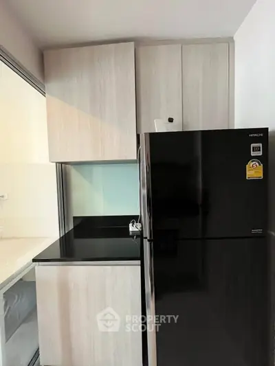 Modern kitchen with sleek black fridge and minimalist cabinetry