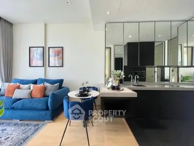 Modern living room with stylish blue sofa and sleek kitchen area in open layout apartment.