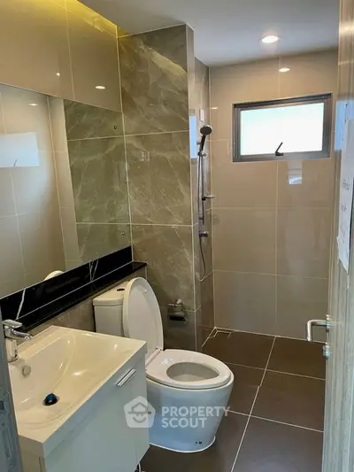 Modern bathroom with sleek design and elegant fixtures, featuring a shower and stylish tiles.