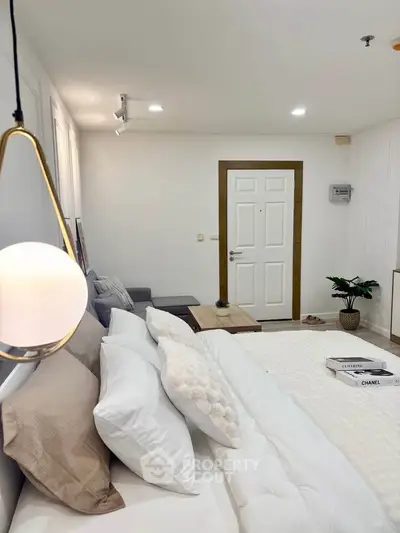 Modern bedroom with cozy decor and stylish lighting in a contemporary apartment.