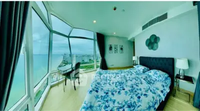 Luxurious bedroom with panoramic ocean view and elegant decor in high-rise apartment.