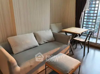 Cozy living room with modern sofa and dining area near large window with city view.