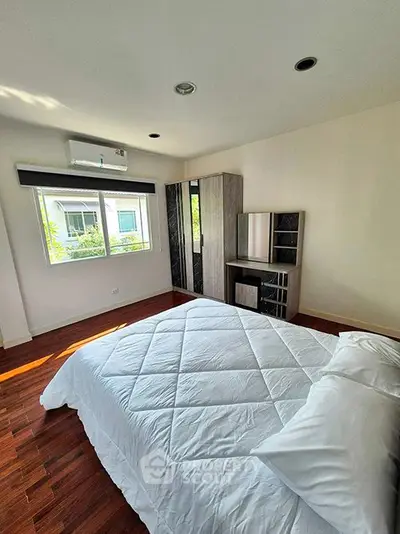 Bright and airy bedroom with modern furnishings and large window view.