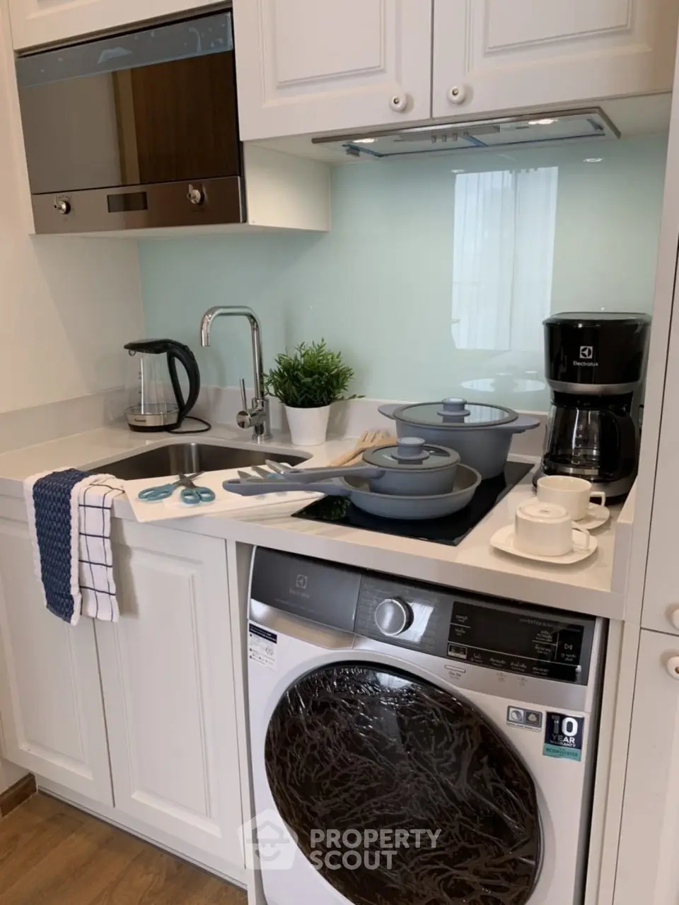 Modern kitchen with built-in appliances and washing machine in compact layout