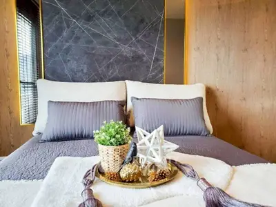 Luxurious bedroom with stylish decor and cozy bedding in modern apartment.