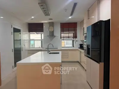 Spacious modern kitchen with island, sleek cabinetry, and large windows for natural light.