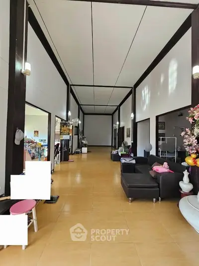 Spacious living room with modern decor and high ceilings, perfect for family gatherings.