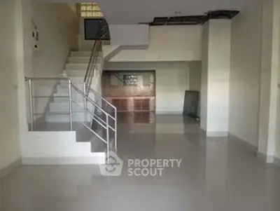 Spacious open-plan interior with modern staircase and glossy floors