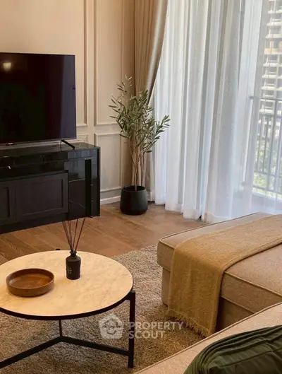 Elegant living room with modern decor, large TV, and balcony view.