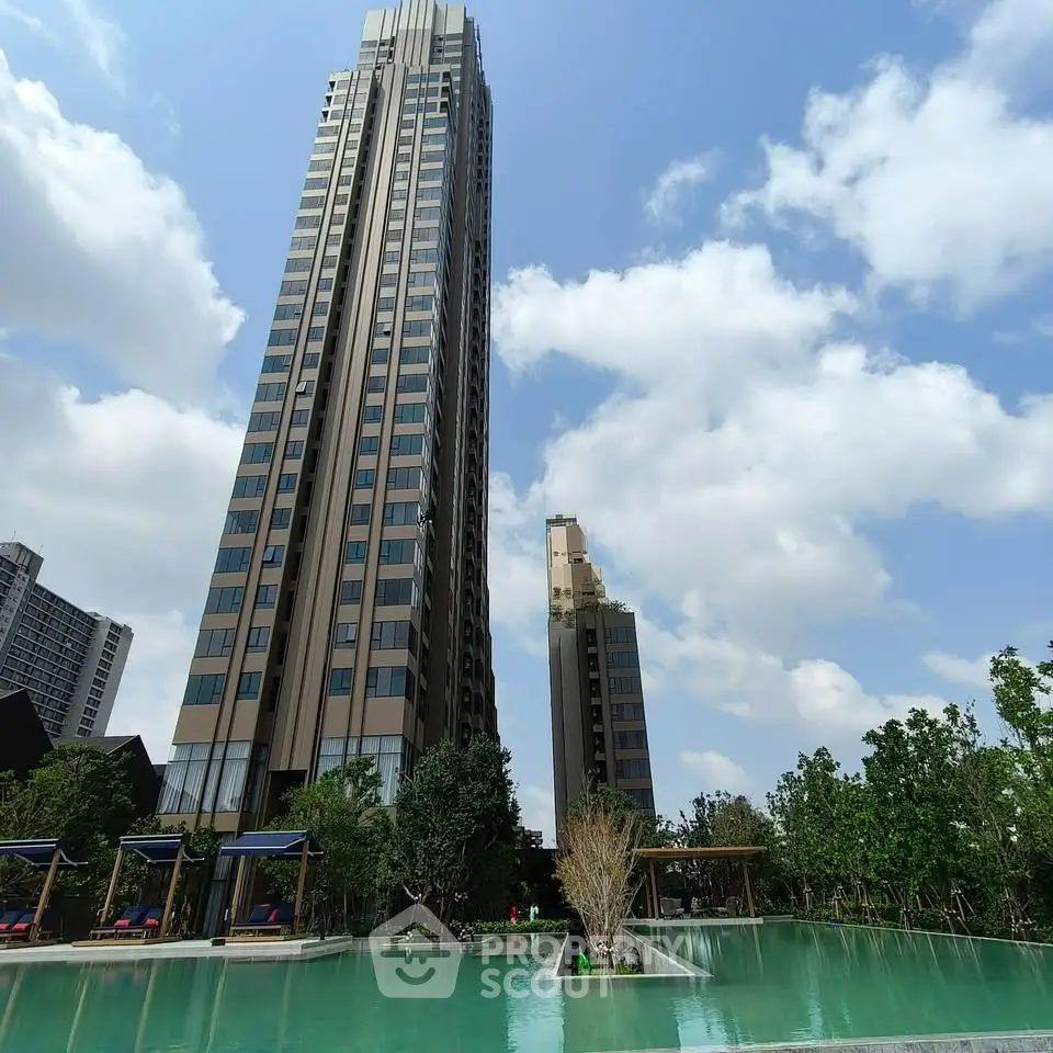 Stunning high-rise building with pool and lush greenery under a clear blue sky.