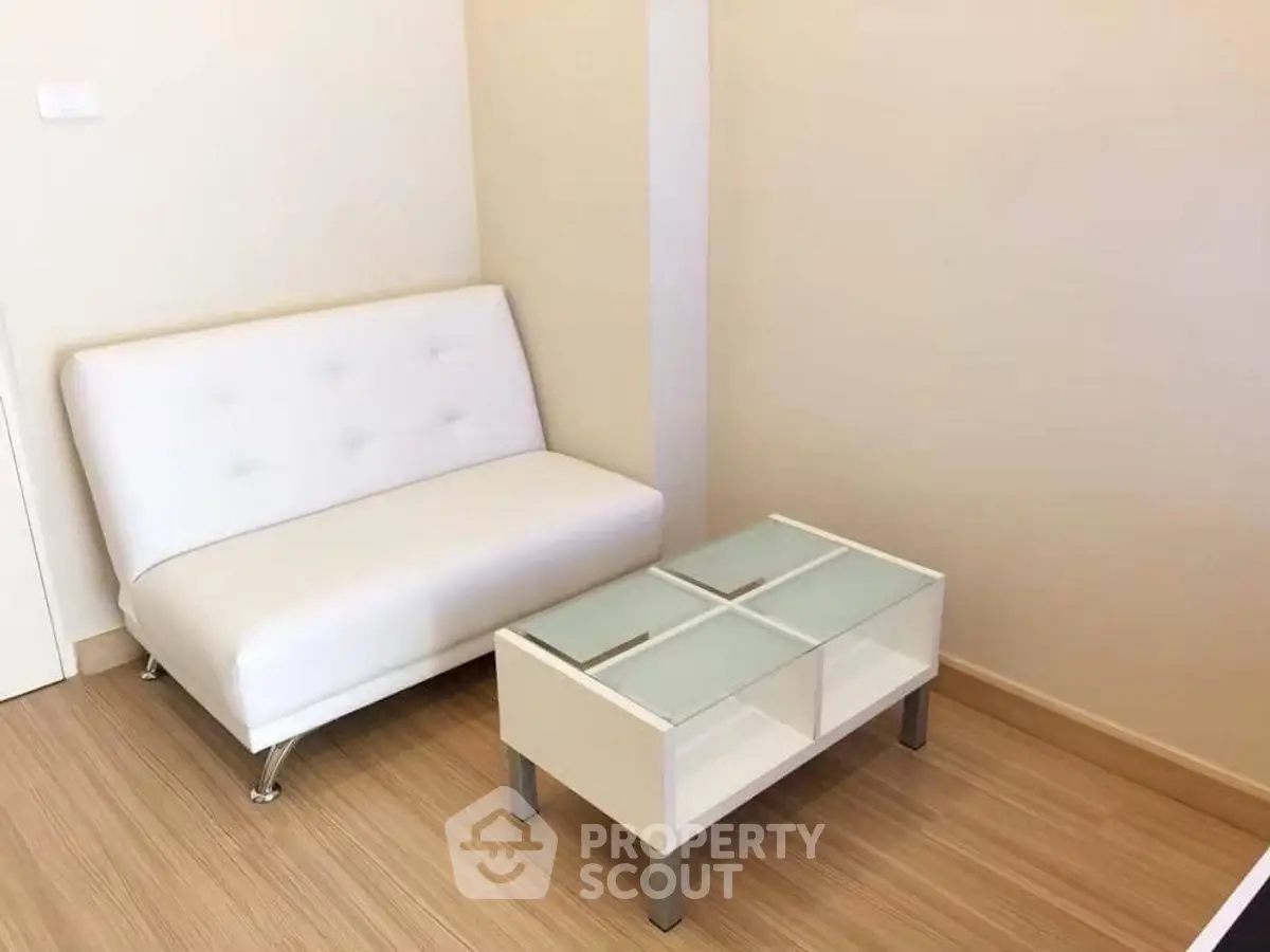 Minimalist small living room with white sofa and glass coffee table