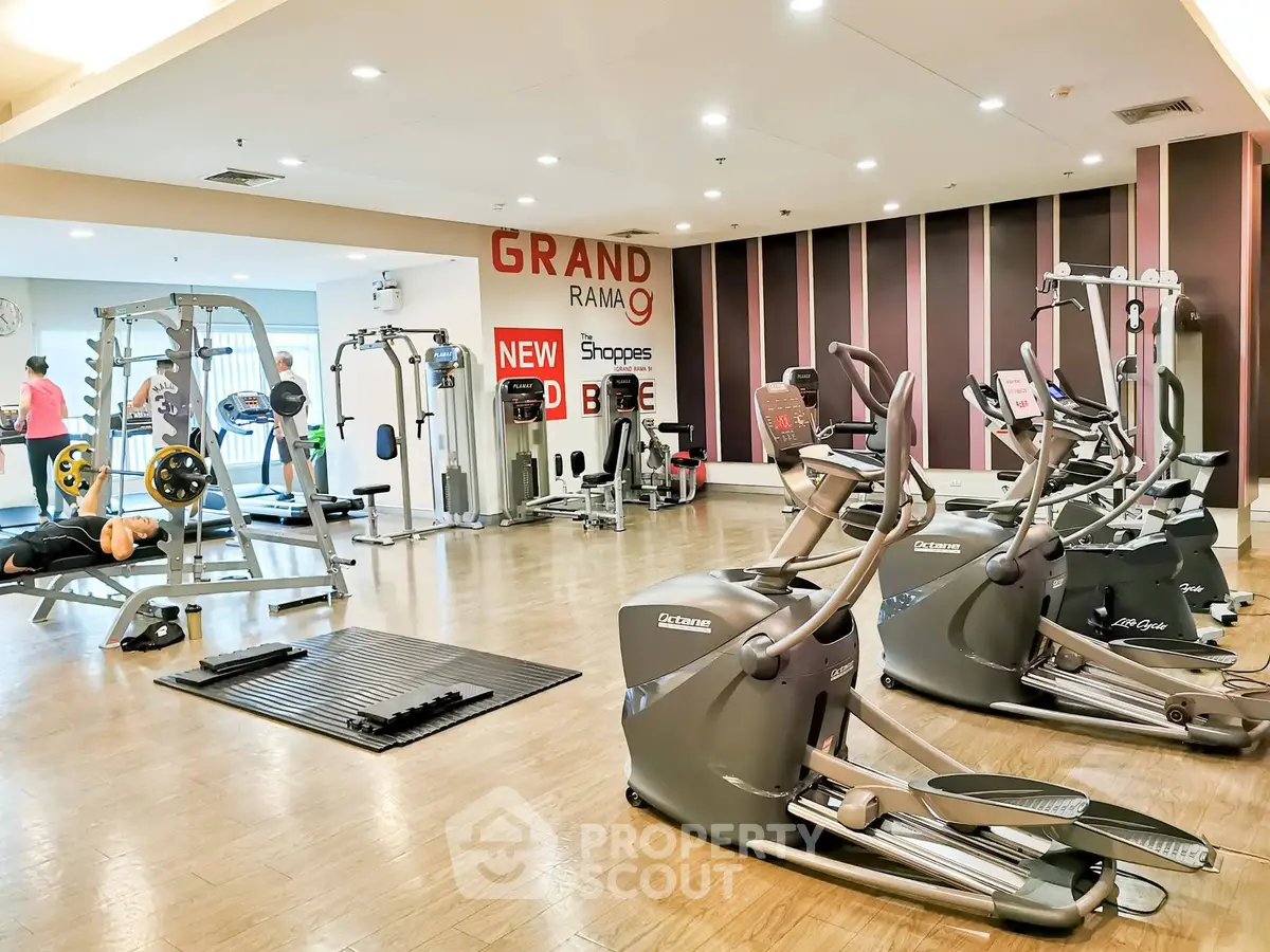 Spacious gym with modern fitness equipment in a luxury residential complex.