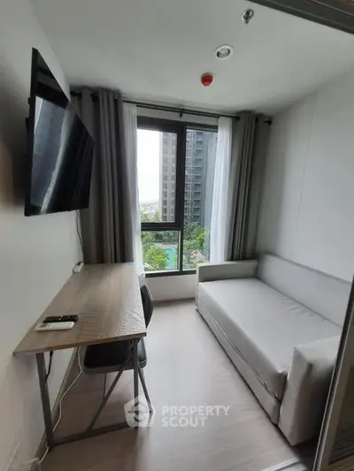 Modern study room with sofa and desk, featuring a large window with city view.