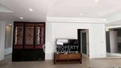 Spacious living room with modern TV setup and elegant wooden decor