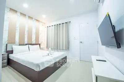 Modern bedroom with sleek design and wall-mounted TV