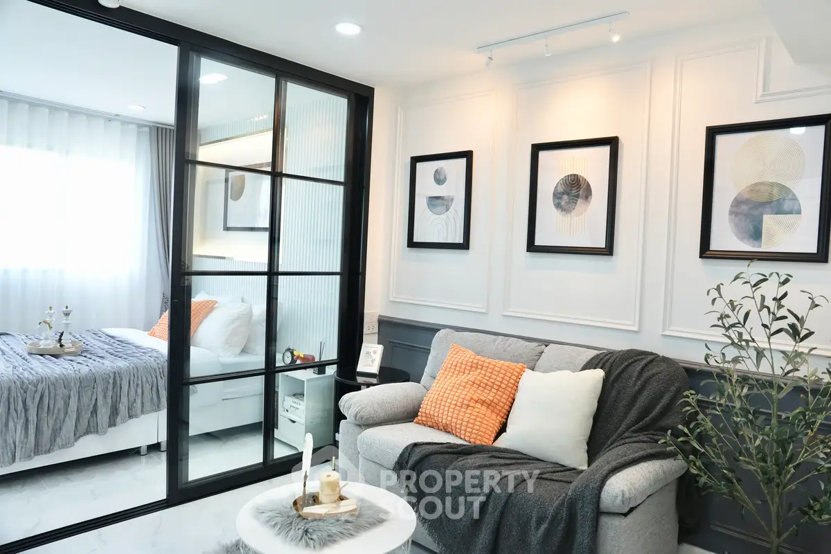 Modern living room with glass partition and cozy bedroom view