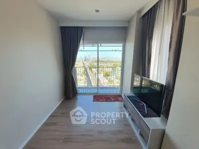 Spacious living room with large windows offering abundant natural light and a panoramic city view, complemented by elegant drapery and modern flooring.