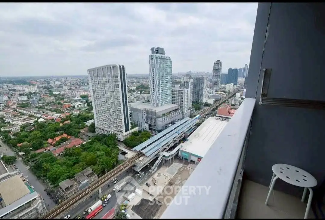 Stunning cityscape view from high-rise balcony overlooking urban skyline and transit station.