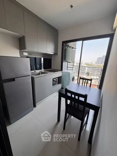 Modern kitchen with sleek cabinetry and city view from balcony