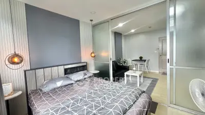 Modern bedroom with stylish decor and sliding glass doors leading to a cozy living area.