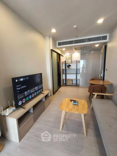 Modern living room with sleek furniture and large TV, perfect for relaxation and entertainment.