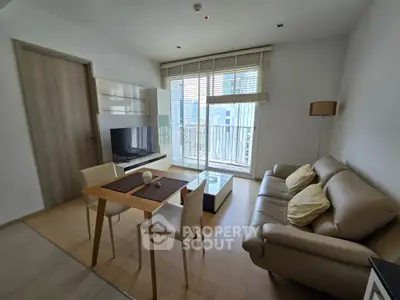 Modern living room with leather sofa, dining table, and large window with city view.