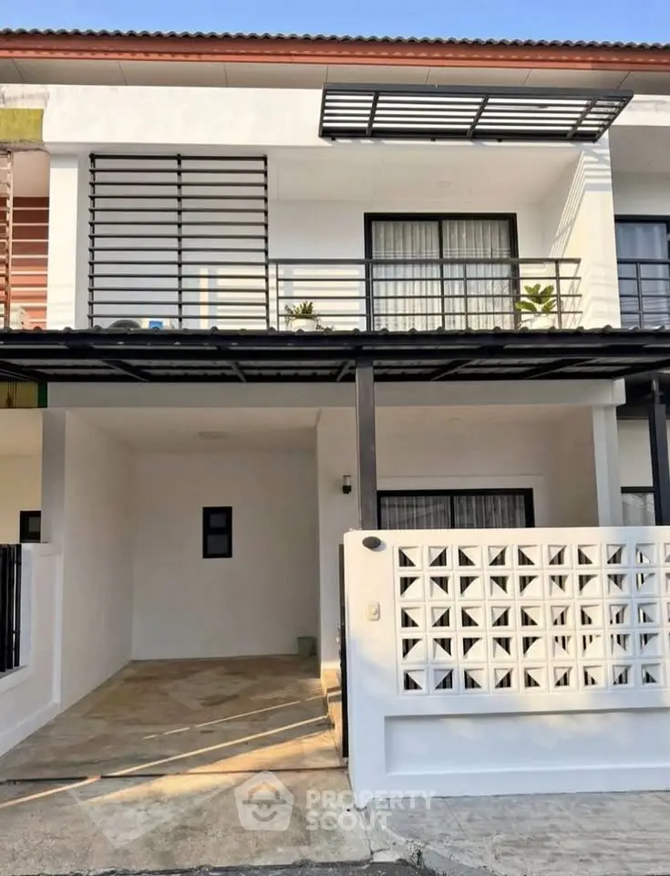 Modern two-story townhouse with sleek balcony and spacious driveway