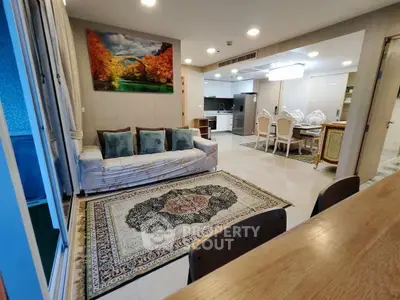 Spacious open-layout living room with elegant kitchen and dining area, featuring modern decor and cozy seating.