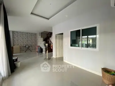 Spacious modern living room with large windows and sleek tile flooring