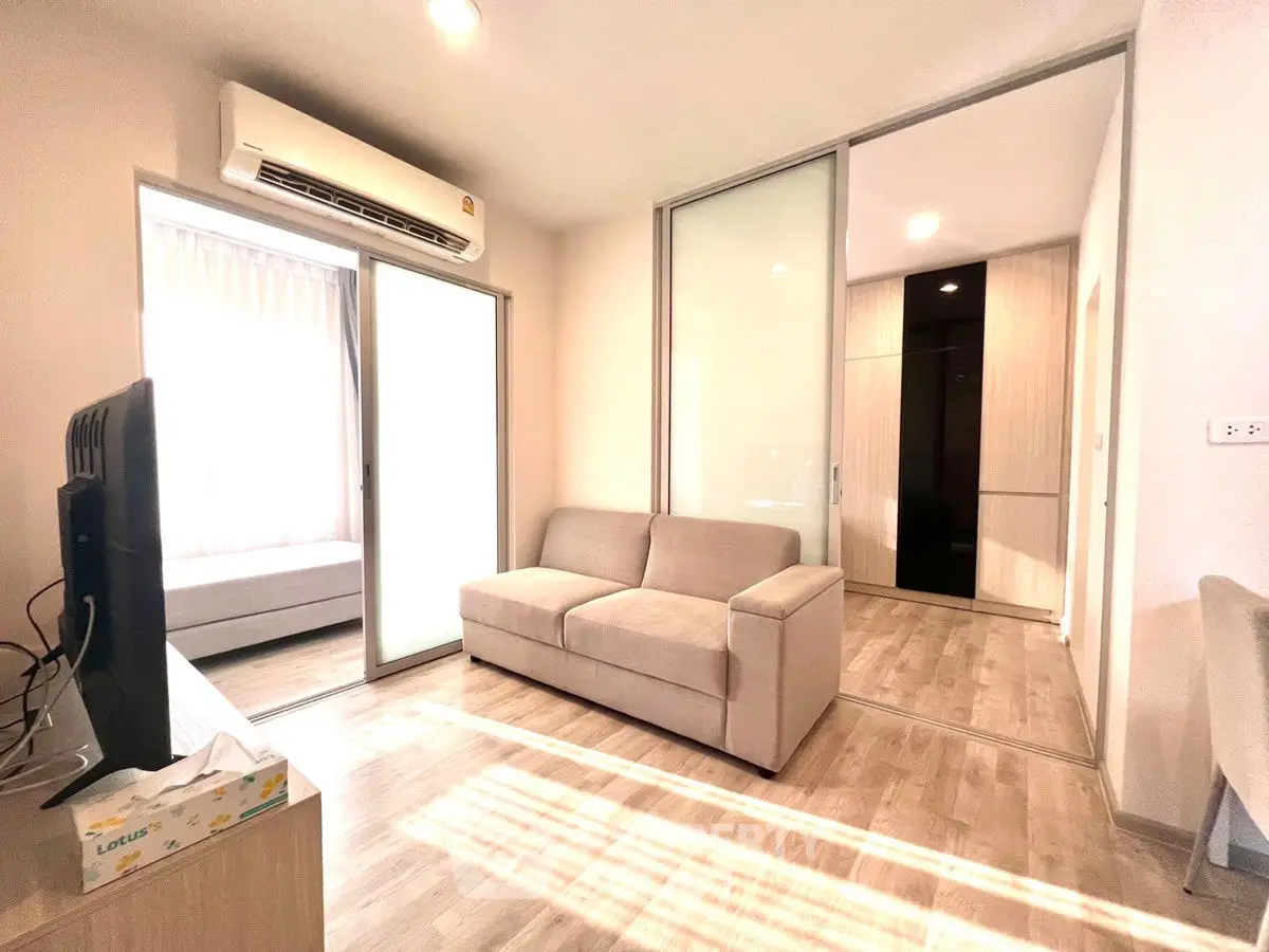 Modern living room with sliding glass doors and cozy sofa in bright apartment