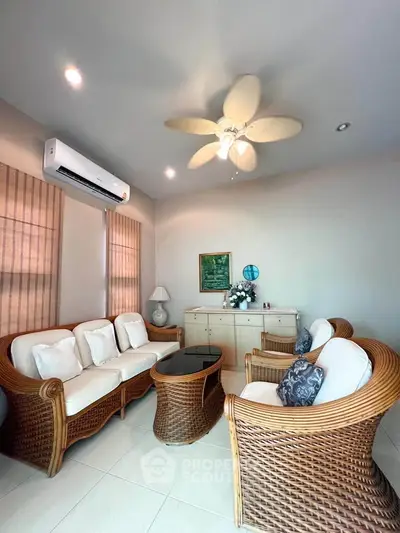 Charming living room with wicker furniture and ceiling fan, perfect for relaxation.