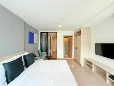 Modern bedroom with stylish decor and ensuite bathroom in a contemporary apartment.