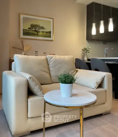 Modern living room with cozy beige sofa and elegant decor near open kitchen.