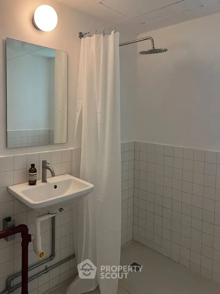 Modern minimalist bathroom with white tiles and shower curtain