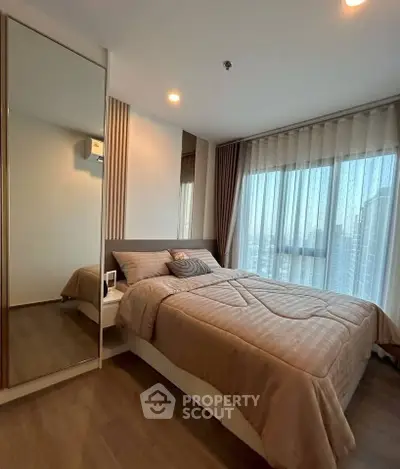 Modern bedroom with large window and elegant decor in a high-rise apartment.