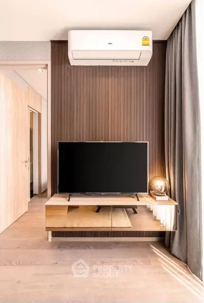 Modern living room with sleek TV setup and stylish wooden paneling, featuring elegant lighting and contemporary decor.