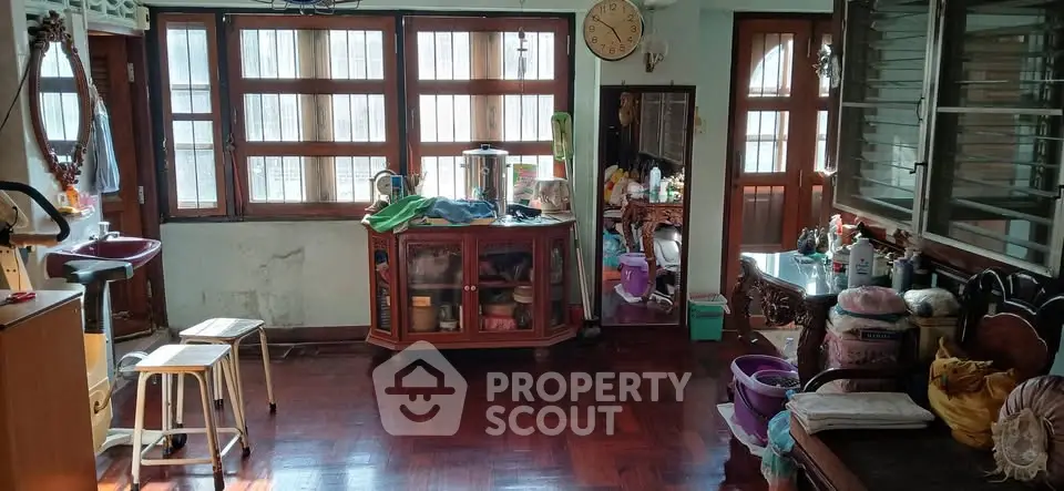 Spacious living room with wooden flooring and large windows, ideal for cozy family gatherings.