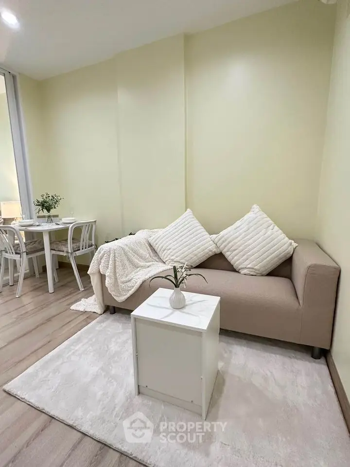 Cozy living room with beige sofa and dining area, perfect for modern living.
