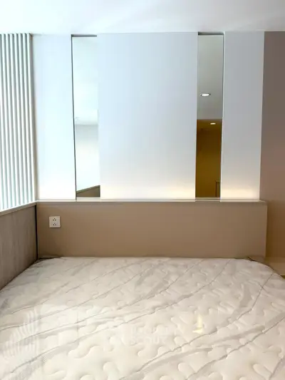 Modern bedroom with stylish design and comfortable mattress, featuring sleek wall panels and ambient lighting.