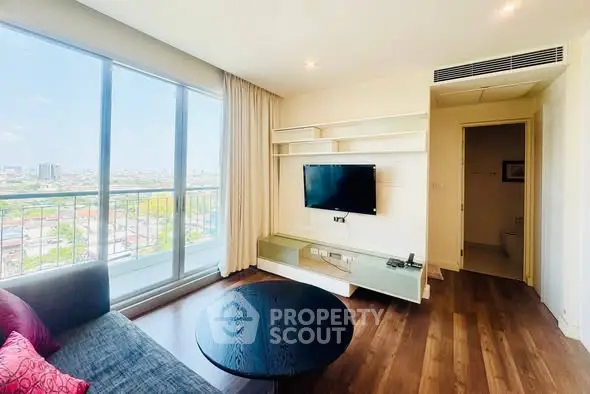 Modern living room with city view, large windows, and stylish furnishings in a high-rise apartment.