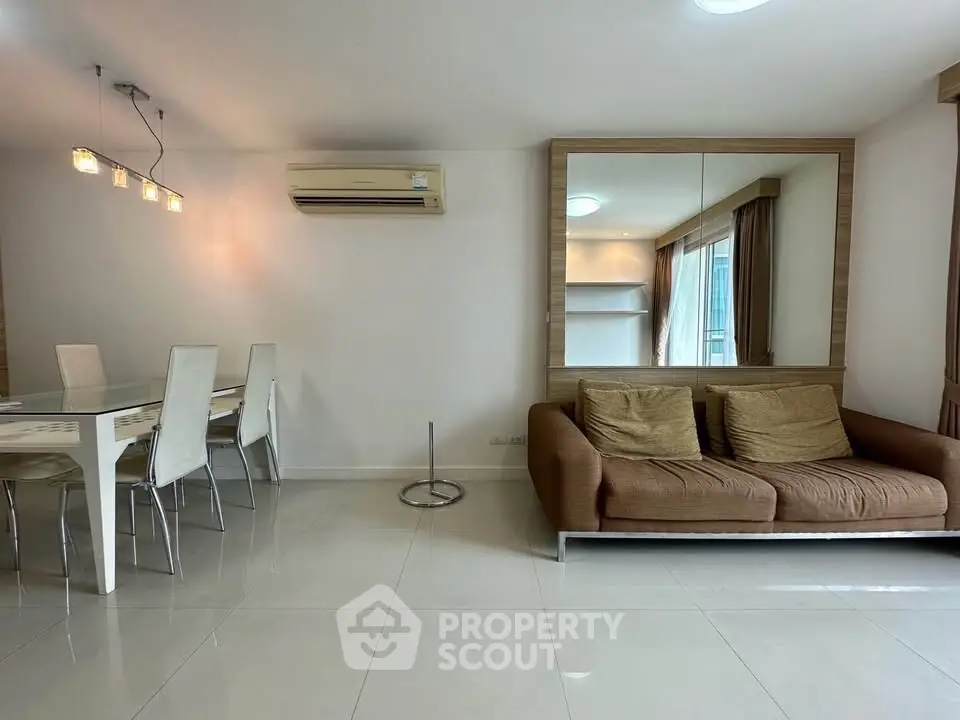 Spacious living room with modern dining area and cozy sofa, perfect for relaxation and entertaining.