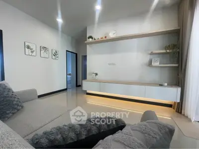 Modern living room with sleek shelving and cozy gray sofa, perfect for relaxation and style.