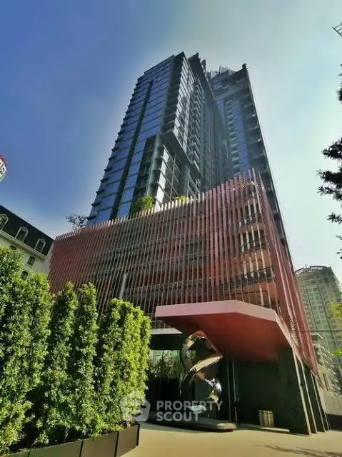 Stunning modern high-rise building with unique architectural design and lush greenery.