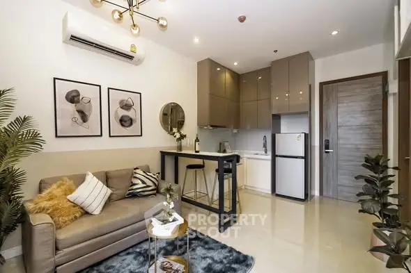 Modern living room with stylish decor and compact kitchen in open layout apartment.