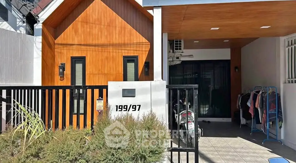 Charming modern house exterior with wooden facade and covered parking area.