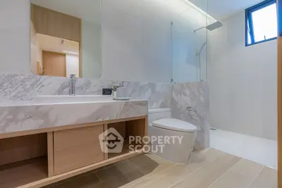 Luxurious modern bathroom with marble accents and spacious shower area.