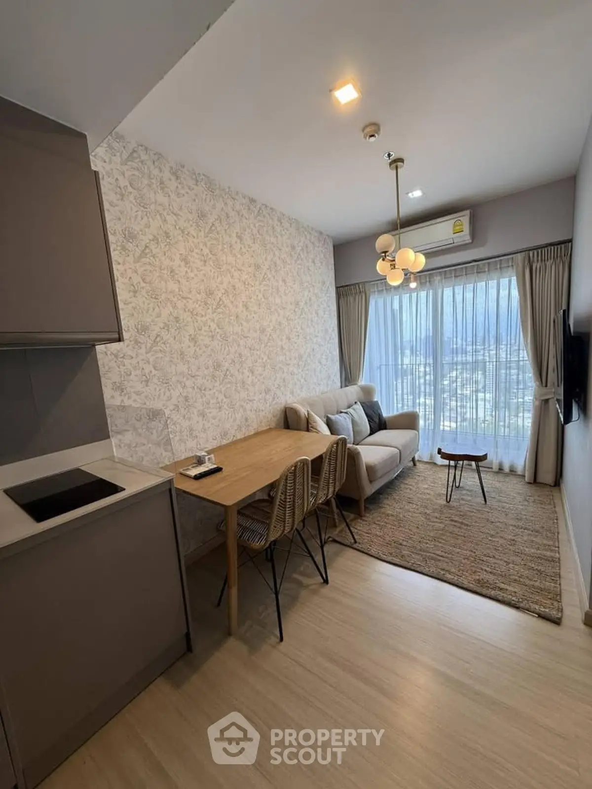 Modern living room with cozy seating and dining area, featuring large window with scenic view.