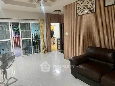 Spacious living room with modern decor and sliding glass doors leading to a balcony.